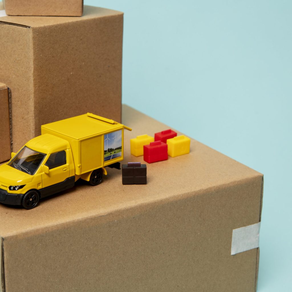 camion-giallo-su-scatola-di-cartone